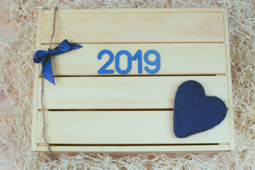 New Year. Blue symbol with and a heart on a wooden box