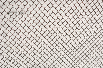 Fototapeta premium Metal mesh closeup. Metal mesh in the snow. Grid texture.