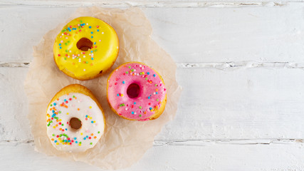 Colored donuts on white background, copy space