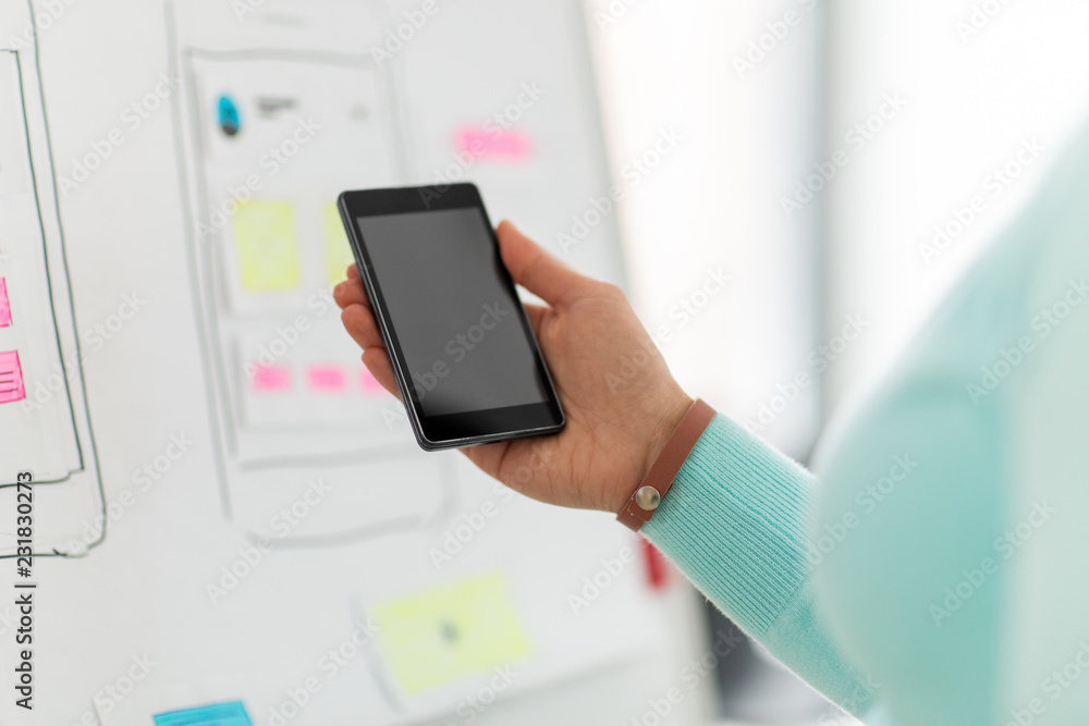 Aufkleber technology, user interface design and people concept - hand of ui designer or developer holding smar