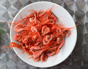 Ready to eat freshly boiled small shrimps on a white plate on a metal table.Seafood concept.
Top...