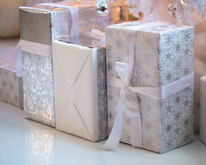 Beautiful white boxes with gifts under the Christmas tree. New Year and Christmas holidays