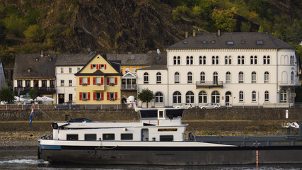 Obraz premium Telephoto shot of large barge sailing down Rhine River in Germany.