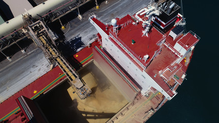 Wide drone shot of ship loading bulk grain in Australian port.