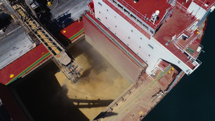 Tight drone shot of ship loading bulk grain in Australian port.