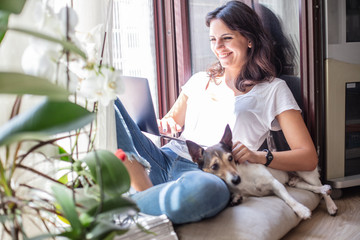 Attractive young woman smiling on a window seat
