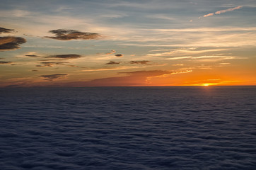 sun setting in the sea of clouds with beautiful and colorful sky above