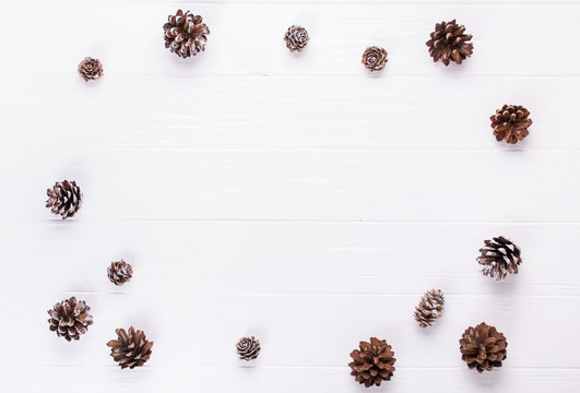 Christmas background. Christmas frame made  pine cones decoration rustic elements on white wood trable.