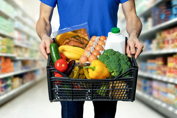 man with food box in hands at grocery store