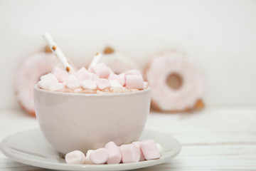 Obraz na płótnie Canvas hot chocolate with marshmallow candy and Christmas decorations on white wooden background