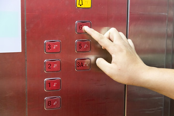 Obraz premium Blind person finger reading braille on elevator lift panel