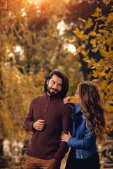 Fototapeta premium Couple in autumn season colored park enjoying outdoors.