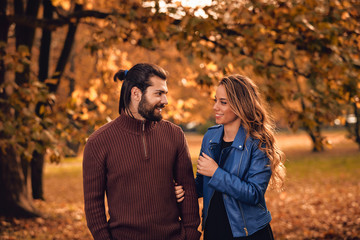 Couple in autumn season colored park enjoying outdoors.