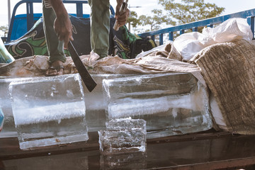hawker cutting ice blocks in heat season in cambodia