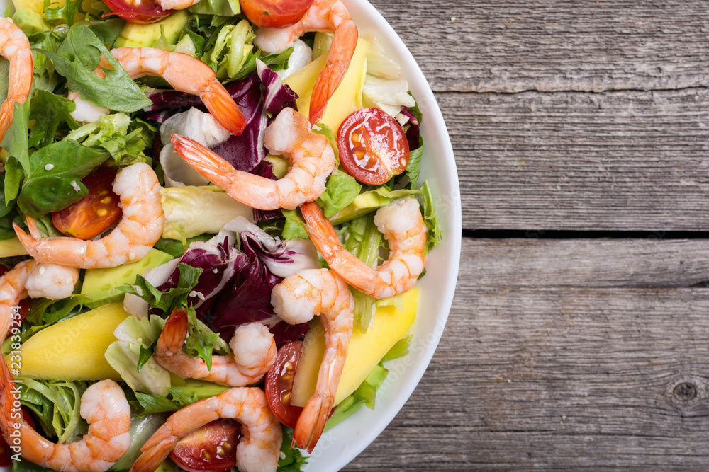 Poster Mix of salad with shrimps , avocado and cherry tomatoes . Healthy food background