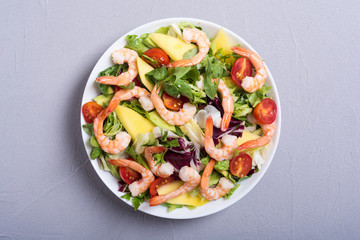 Mix of salad with shrimps , avocado and cherry tomatoes . Healthy food background