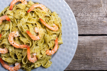 Pasta tagliatelle with sauce pesto and shrimps . Italian food background