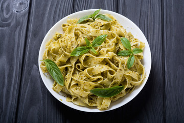 Pasta tagliatelle with green sauce pesto . Italian food background