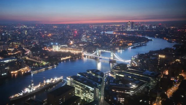 time lapse London skyline with illuminated Tower bridge and Canary Wharf in sunrise time, UK