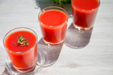 Red tomato juice in a glass, bright morning sun, healthy breakfast