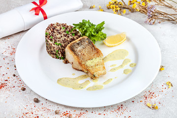 Served pike perch fillet with quinoa on light background. Delicious close up view. Picture for recipes or books. Close up 45 degree view. Copy space for text, logo or brand