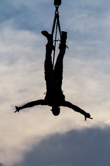 BERLIN, GERMANY - July 29, 2018: Silhouette of a male Bungee Jumper against dramatic skies