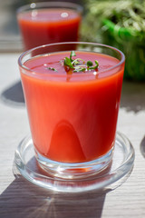 Red tomato juice in a glass, bright morning sun, healthy breakfast