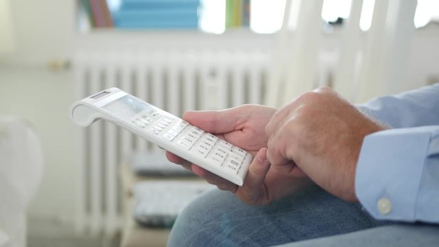 Businessman in Office Room Make Financial Calculation with Adding Machine