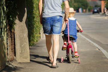 Obraz premium Father is teaching his daughter to ride a bicycle.
