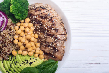Buddha bowl with broccoli , quinoa , grilled chicken , avocado and spinach . Healthy vegan salad . Superfood