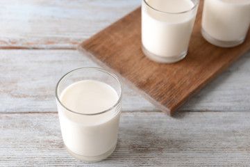 Glasses of fresh milk on wooden table