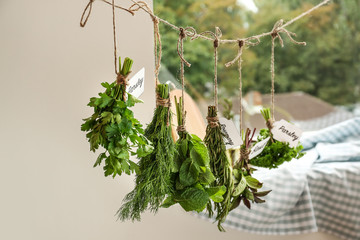 Different fresh herbs hanging on string indoors