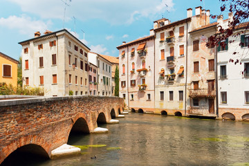 Fototapeta na wymiar Treviso, Italy August 7, 2018: the river flows among the old buildings of the city.