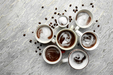 Many cups with tasty aromatic coffee on light table