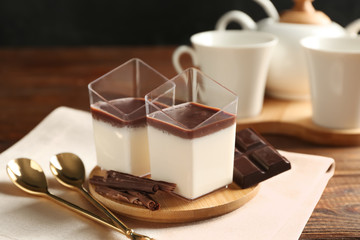 Glasses with tasty chocolate panna cotta on wooden table