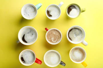 Many cups with tasty aromatic coffee on color background, flat lay