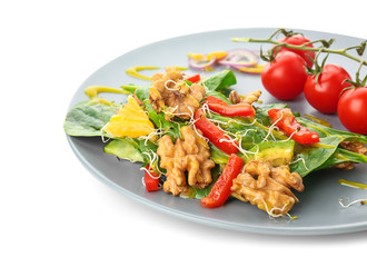 Delicious fresh salad with walnuts on plate, isolated on white
