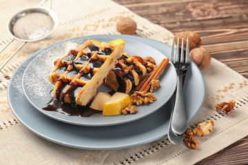 Tasty waffles with chocolate, fruit and walnuts on plate