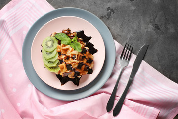 Tasty waffles with fruits and berries on plate