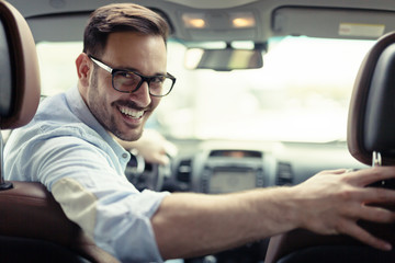 Handsome businessman driving a car to work