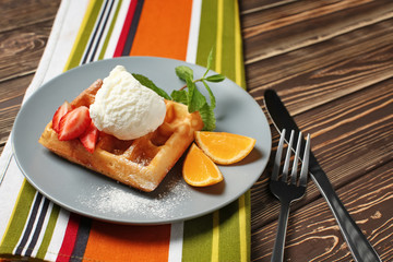 Tasty waffle with ice cream and fruits on plate