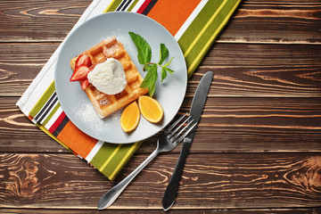 Tasty waffle with ice cream and fruits on plate