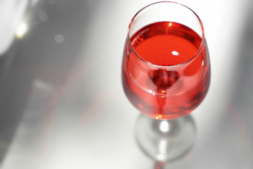 Glass of tasty wine on light table