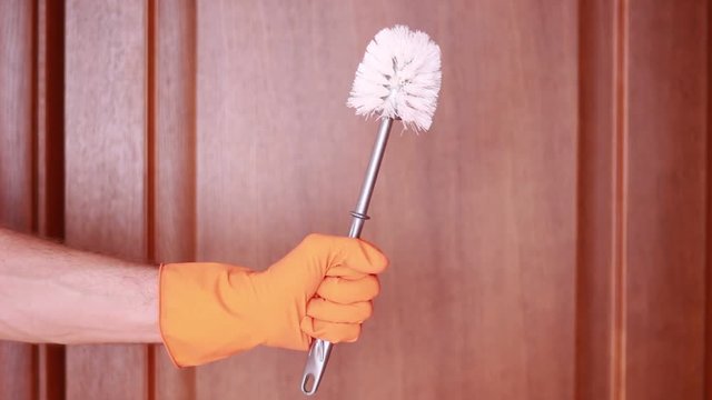 Holding toilet brush in rubber gloves