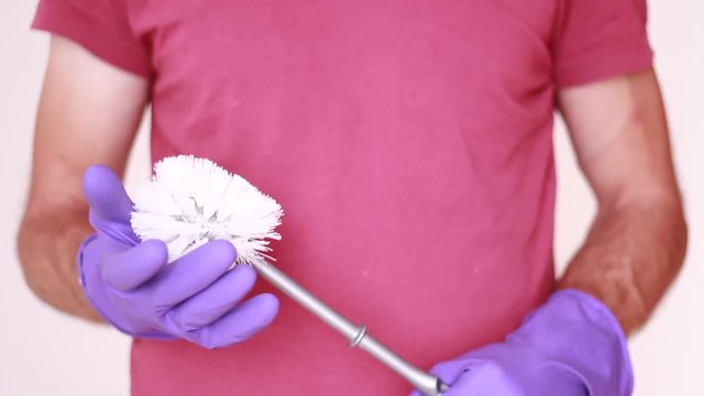 White toilet brush in male hands