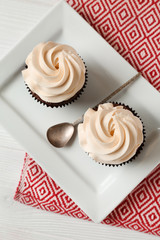 Tasty chocolate cupcakes on white table