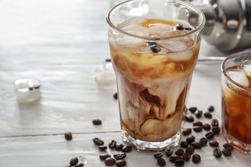 Glasses with cold coffee on white table