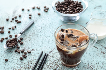 Glass cup with cold coffee on light table