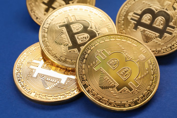 Golden bitcoins on color background, closeup