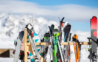 Photo of multi-colored skis in snow at winter resort in afternoon.